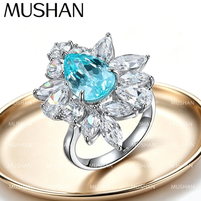 Bague de fiançailles classique MUSHAN pour femme, en argent sterling 925 plaqué or 18 carats, ornée d'une émeraude ronde de laboratoire bleu-vert.